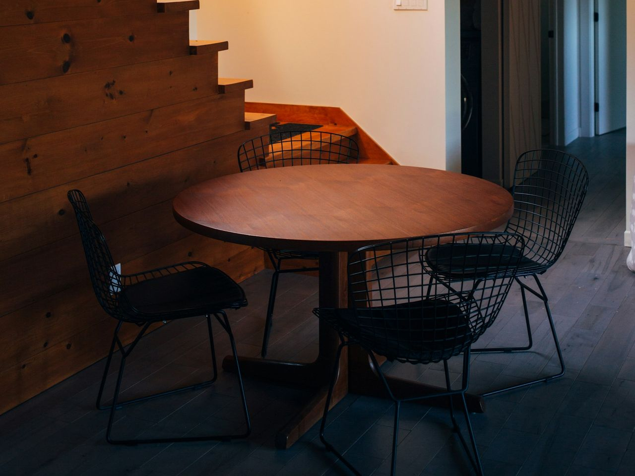 round brown wooden table and chairs under white pendant lamp